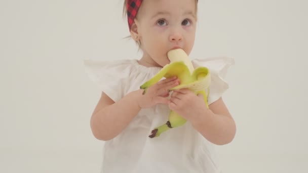 Niña Diadema Cuadros Falda Está Comiendo Plátano Grande Primer Plano — Vídeos de Stock