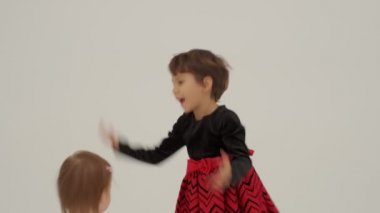 Little short hair girl plays toys with little sister wearing diaper