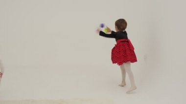 Little short hair girl plays toys with little sister wearing diaper