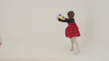 Little short hair girl plays toys with little sister wearing diaper