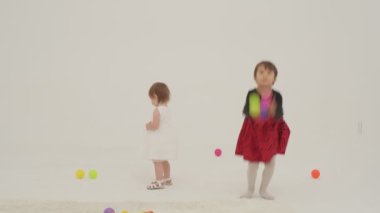 Little short hair girl plays toys with little sister wearing diaper