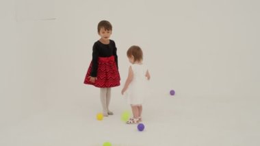 Little short hair girl plays toys with little sister wearing diaper