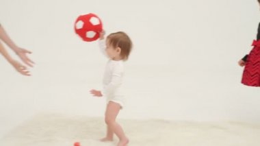 Beyaz bir odada oyuncak oynayan iki küçük kız. Yavaş çekim
