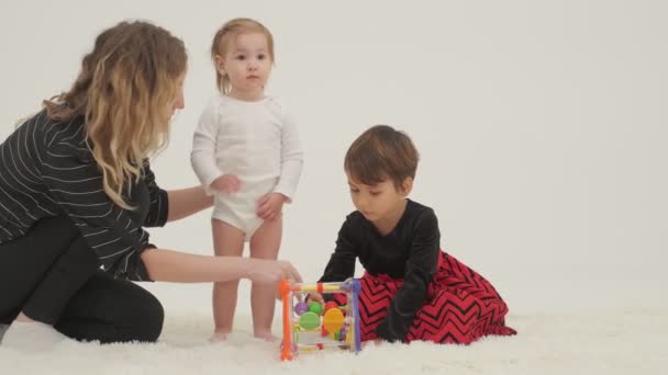 Δύο Κοριτσάκια Παίζουν Παιχνίδια Ένα Λευκό Δωμάτιο Αργή Κίνηση — Αρχείο Βίντεο