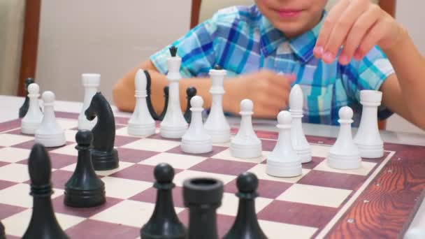 Boy Blue Checkered Shirt Plays Chess Light Wall Back Closeup — Stock Video