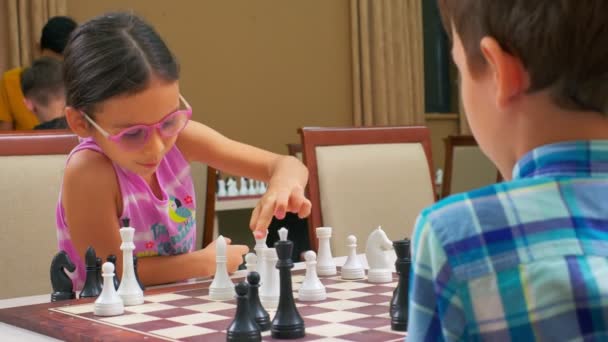 Girl Sleeveless Pink Shirt Bright Pink Frame Glasses Plays Chess — Stock Video