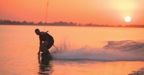 醒着的冲浪者骑在湖上的木板上 落日时拍摄的布景 茶色床板 — 图库视频影像
