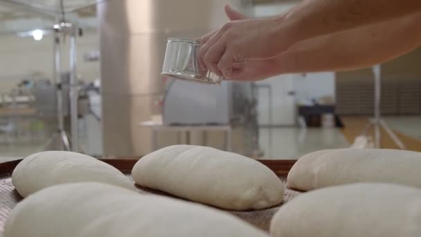 Пекари Посыпают Муку Пластикового Соуса Множество Готовых Выпечке Хлебов Которые — стоковое видео