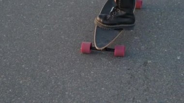 Dubai 'deki kum tepelerinin arasında çölde kaykay süren bir kız. Yaklaş, Ağır çekim..