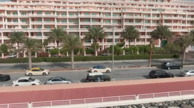 Deniz kıyısında yol boyunca giden bir arabanın arkasındaki insansız hava aracının uçuşu.