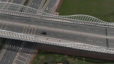 Drone, palmiye ağaçlarıyla çevrili yolda arabanın hareketini vuruyor.