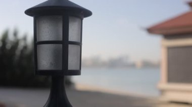 Körfezin kumlu sahilinde, Çin tarzında küçük bir ev şehrin arka planına karşı.