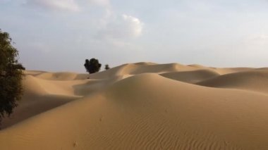 İnsansız hava aracı çöldeki kum tepeleri üzerinde uçuyor.