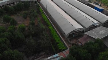 İnsansız hava aracı meyve ve üzüm bahçeleriyle çevrili seraların üzerinde yavaşça uçuyor.