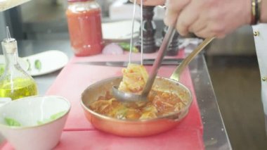 Şef hazır makarna ile birlikte bir yemek servis eder. Ağır çekimde yakın çekim