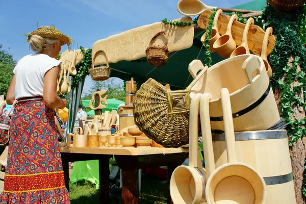 Een vrouw koopt souvenirs gemaakt van cederhout. — Stockfoto