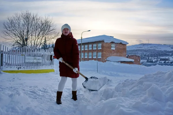 Menina limpa o território da neve — Fotografia de Stock