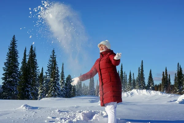 Dziewczyna rzuca śnieg w słoneczne popołudnie. — Zdjęcie stockowe