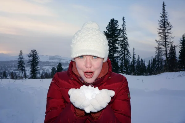 Meisje houdt de witte sneeuw op de handen. — Stockfoto