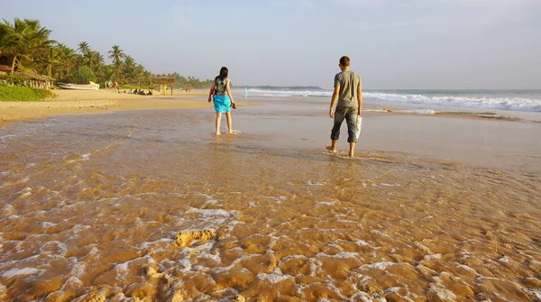 Jongen en meisje lopen op het water van de Oceaan. — Stockfoto