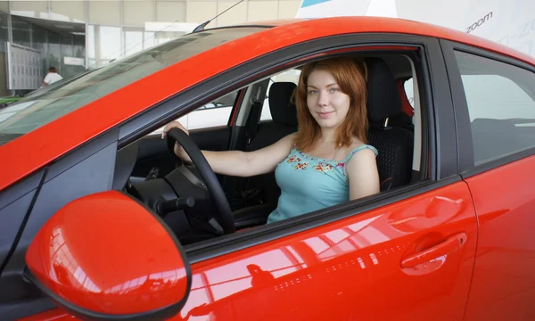 bir otomobilin direksiyon arkasındaki kız.