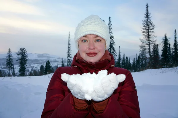 Meisje houdt van de witte sneeuw op de handen. — Stockfoto