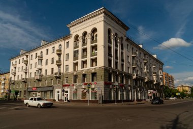 Krasnoyarsk, Krasnoyarsk Region, RF - July 19, 2021: A corner house of Stalin's construction in 1956 with beautiful stucco molding stands at the intersection of 14 Profsoyuzov Street and 130 Bograda Street on a summer day. clipart