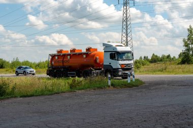 Krasnoyarsk, Krasnoyarsk Bölgesi, RF - 31 Temmuz 2021: Turuncu tanklı ve Rusça yazılı bir yakıt kamyonu güneşli bir yaz gününde yol kenarında duruyor.