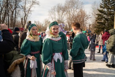 Krasnoyarsk, Krasnoyarsk Bölgesi, RF - 14 Mart 2021: Kokoshniks ve Rus halk kostümlü güzel kızlar, Farewell 'de şehir parkındaki kış tatilinde.