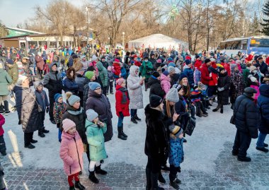 Krasnoyarsk, Krasnoyarsk Bölgesi, RF - 14 Mart 2021: Farklı yaşlarda bir kasaba halkı şehrin merkez parkındaki bir meydanda duruyor.