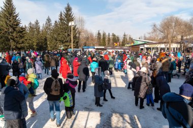 Krasnoyarsk, Krasnoyarsk Bölgesi, RF - 14 Mart 2021: Farklı yaşlarda bir kasaba halkı, Farewell-Kış tatili sırasında şehrin merkez parkında toplandı.