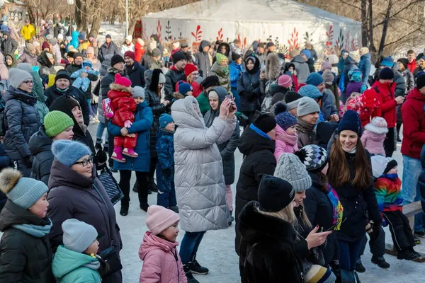 2021年3月14日 俄罗斯联邦克拉斯诺亚尔斯克州克拉斯诺亚尔斯克市 一名妇女站在一群人中间 一边打电话拍照 一边站在公园里过冬告别节 — 图库照片
