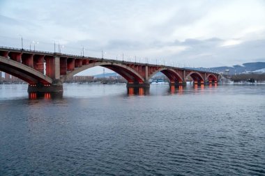 Krasnoyarsk şehrinin sağ kıyısından Yenisei Nehri 'nin üzerinde gece aydınlatmasıyla Komün Köprüsü' nün (1961) görüntüsü. Rusya.