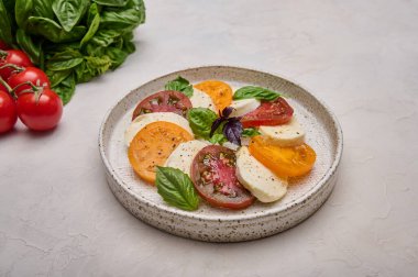 Kırmızı domatesler, taze fesleğen ve mozzarella peyniri ile kaplıcayı kapat.