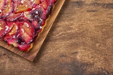 Köy arka planında ahşap kesim tahtasındaki erikli tart ya da turta