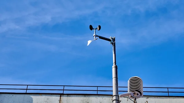 Rychlost větru Anemometer Weathervane proti modré obloze s mraky — Stock fotografie