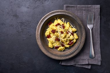 Akdeniz ve parmesanlı patates gnocchi ve seramik tabakta kurutulmuş domates. Düz yatıyordu