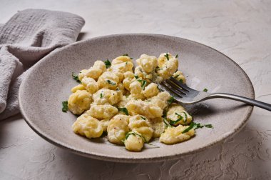 Patates, un hamuru, krema sosu ve maydanozla hazırlanmış geleneksel Akdeniz gnocchi 'sini kapatın.
