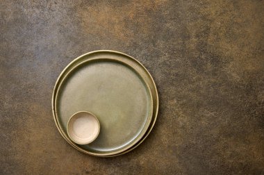 Boş yeşil seramik, iki tabak ve kırsal arka planda bir tencere.