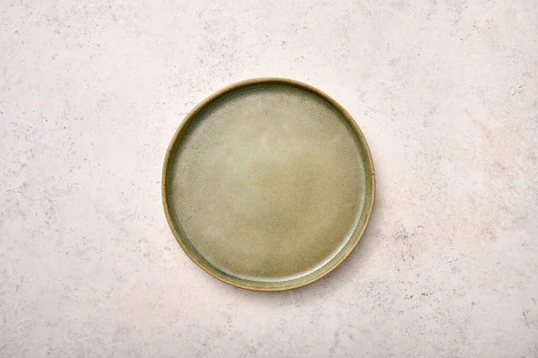 Empty green rustic ceramic plate on light textured marble background — Stock Photo, Image