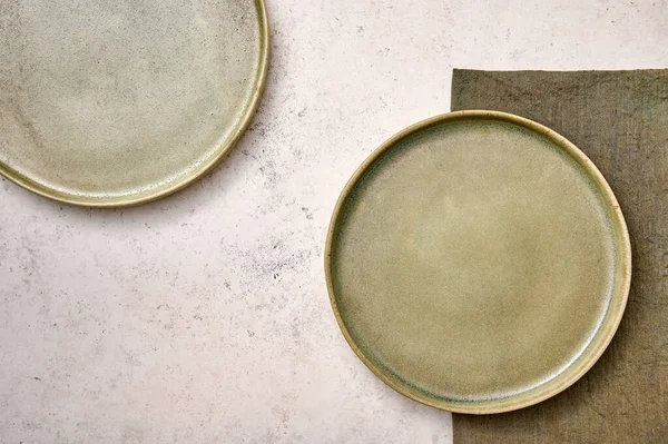 Dos platos verdes con servilleta sobre fondo blanco texturizado —  Fotos de Stock