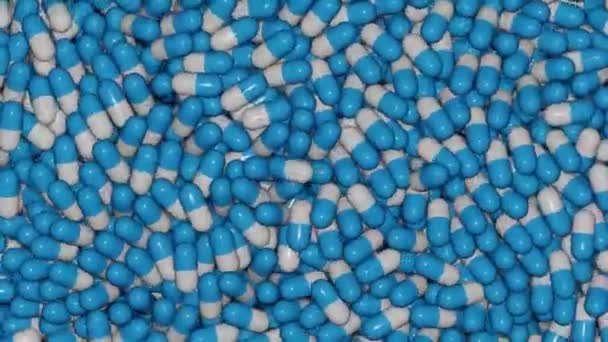 Řádky 3D vykreslení zblízka modré a bílé pilulky pádu a pohybuje se na dopravníku — Stock video