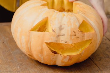 Küçük turuncu balkabağı, ahşap masada kriko-fener.