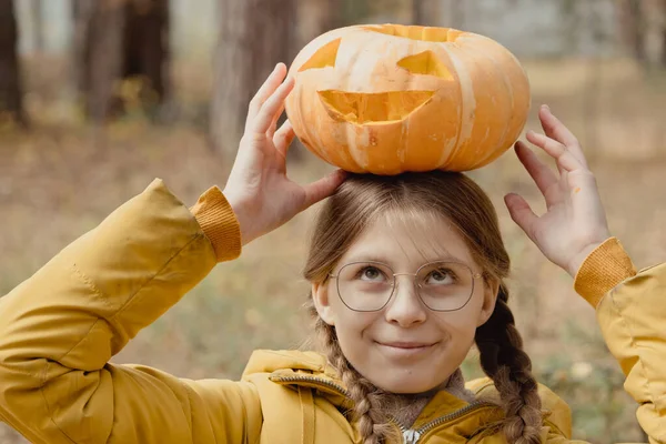 ハロウィンのカボチャを頭にした幸せな子供の女の子 ジャック ランタンの装飾の近くの庭のパーティーの準備 — ストック写真