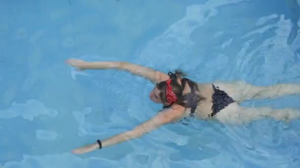 穿着黑色游泳衣 红色头巾游泳和漂亮的游泳池带的漂亮性感女子的头像 享受暑假或旅行度假的妇女 — 图库视频影像