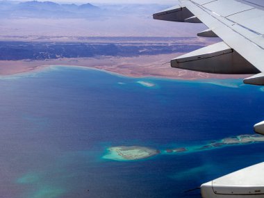 Bulutların ve gökyüzünün üstündeki hava manzarası, ilham konsepti. Özgürce uçmak. Uçuş, mercanlarla birlikte uçaktan tropikal denize görüş. Turbo-jet uçak motoru, nakliye 4K. Yolcu otobüsü