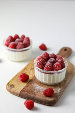 Beyaz arka planda ahududulu İtalyan panna cotta.