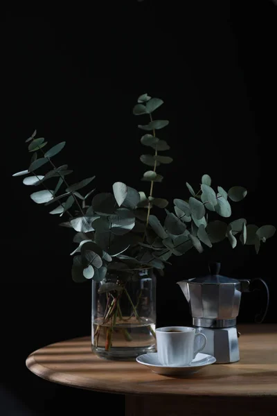 Tasse de café, cafetière geyser et bouquet d'eucalyptus sur table en bois. Espace de copie — Photo