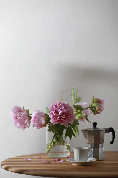 Cup of coffee, geyser coffee maker and bunch of peony flowers on wooden table. Copy space — Photo