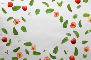Yaz arkaplanı, taze kiraz meyveli çerçeve ve beyaz arka planda nane. Düz yatıyordu. Yaz meyveleri konsepti. Boşluğu kopyala